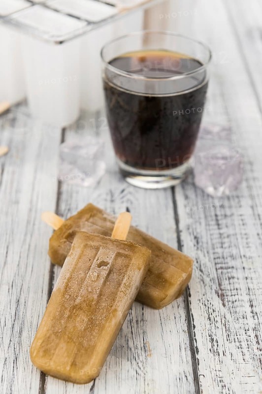 Some homemade Cola Popsicles (close-up shot, selective focus) on vintage background