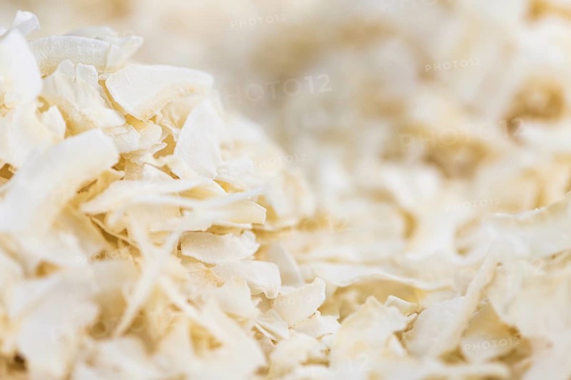 Coconut Chips (fresh) as detailed close-up shot, selective focus)