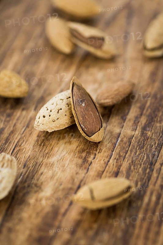 Roasted and salted Almonds (with shell) on a vintage background (close-up shot)