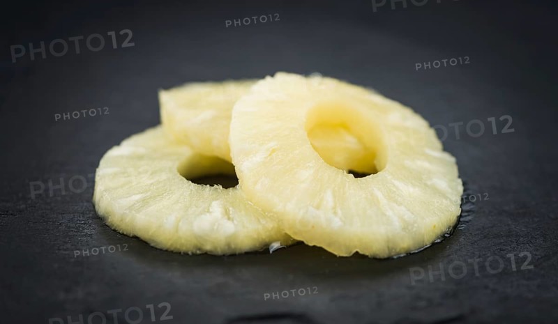 Some fresh Preserved Pineapple Rings on a vintage slate slab, selective focus, close-up shot
