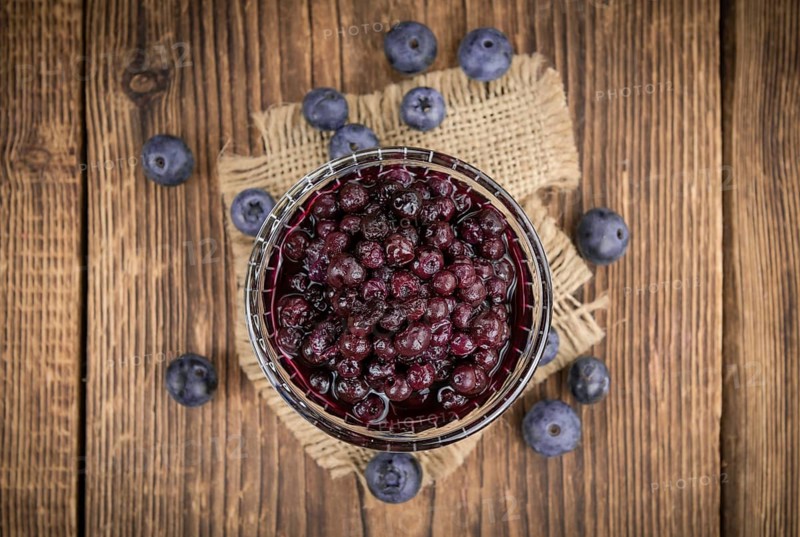 Homemade Preserved Blueberries on an wooden table as detailed close-up shot, selective focus