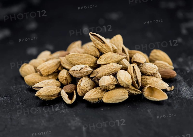 Almonds in shell (roasted and salted) on a vintage background (close-up shot)