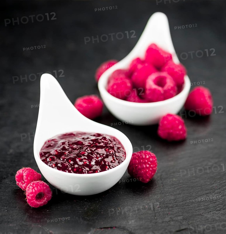 Portion of Raspberry Jam on a rustic slate slab, selective focus, close-up shot