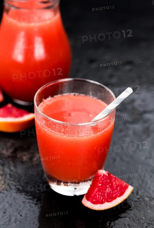 Slate slab with freshly squeezed Grapefruit Juice (selective focus, close-up shot)