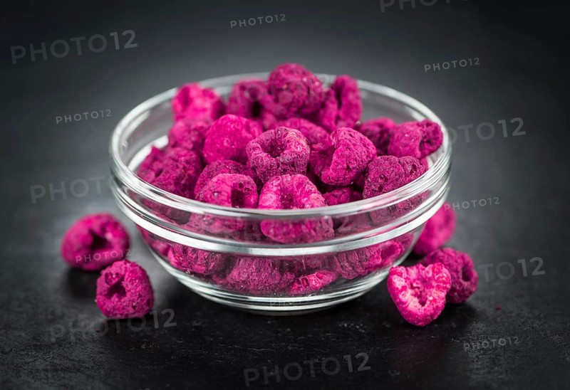 Portion of Dried Raspberries as detailed close up shot on a slate slab, selective focus