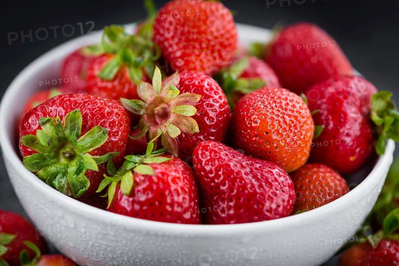 Portion of Strawberries as detailed close up shot on a slate slab, selective focus