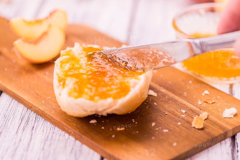 Peach Jam on an old wooden table as detailed close-up shot, selective focus