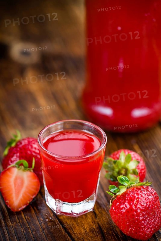 Fresh made Strawberry liqueur on an old and rustic wooden table, selective focus, close-up shot