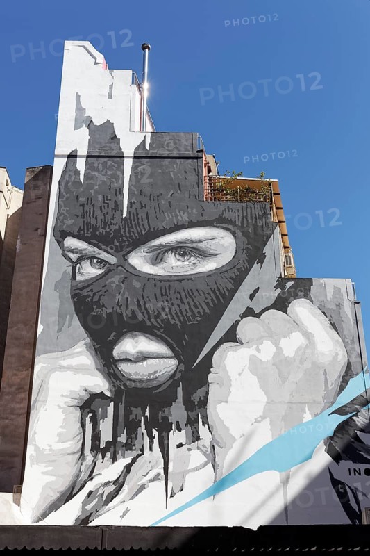 Portrait of a masked man with a clenched fist, Apocalypse now, mural in scarlet white by Greek street artist INO, Psirri neighbourhood, Athens, Greece, Europe
