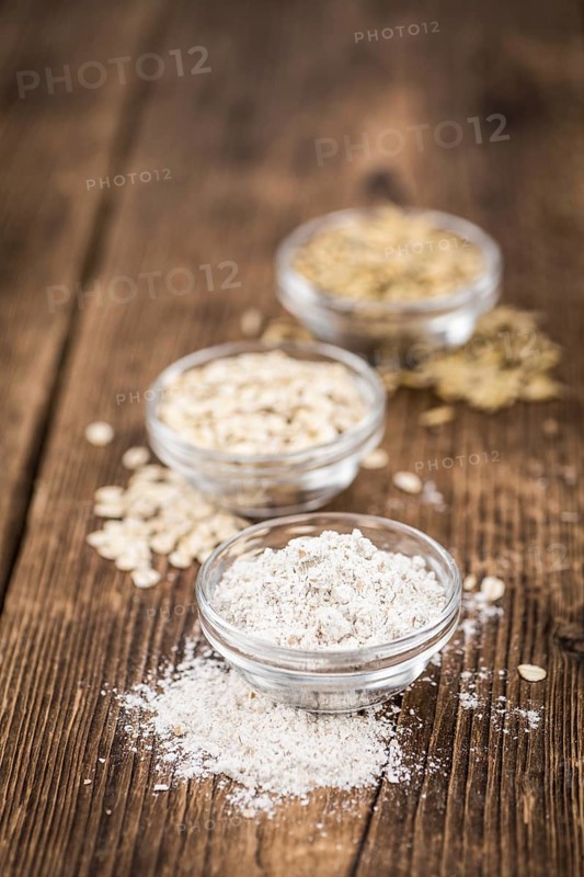 Vintage wooden table with Oat Flour (selective focus, close-up shot)