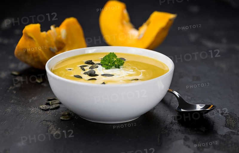 Fresh made Pumpkin Soup (close-up shot) on a vintage background (selective focus)