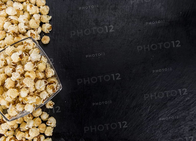 Fresh made Popcorn on a vintage background as detailed close-up shot