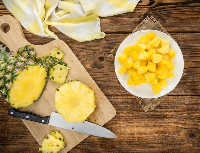 Sliced Pineapple on rustic wooden background as close-up shot