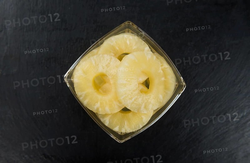 Preserved Pineapple Rings on a vintage slate slab as detailed close-up shot, selective focus