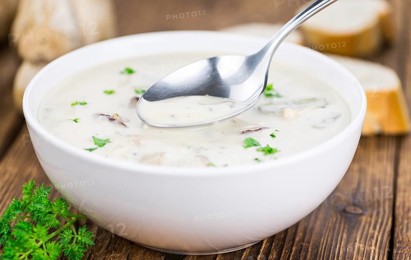 Homemade Porcini Soup on an wooden table as detailed close-up shot, selective focus