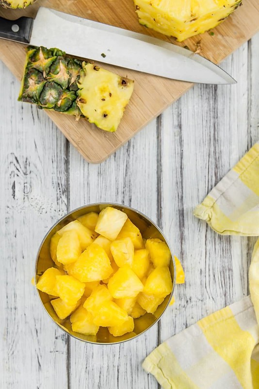 Sliced Pineapple on an old wooden table as detailed close-up shot, selective focus