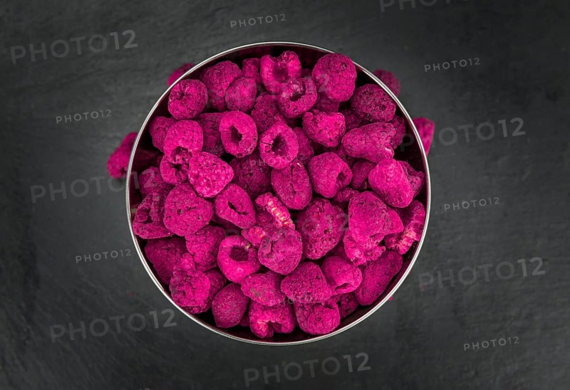 Dried Raspberries on a vintage slate slab as detailed close-up shot, selective focus