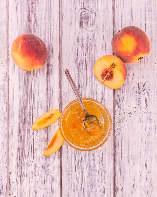 Peach Jam on an old wooden table as detailed close-up shot, selective focus