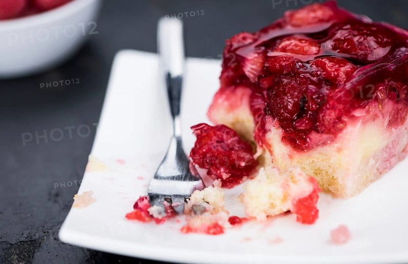 Fresh made Raspberry Cake on a rustic slate slab (close-up shot, selective focus)