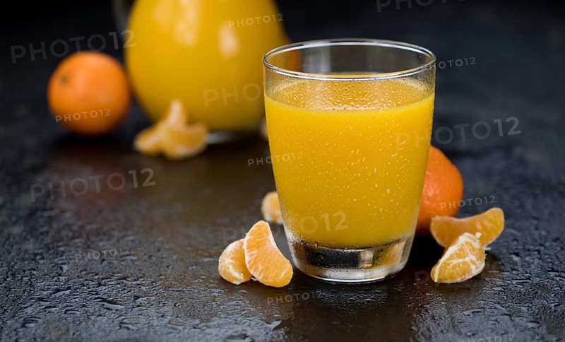 Portion of fresh made Tangerine Juice (close-up shot, selective focus)