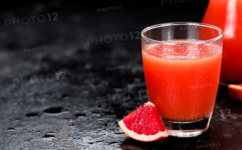 Slate slab with freshly squeezed Grapefruit Juice (selective focus, close-up shot)