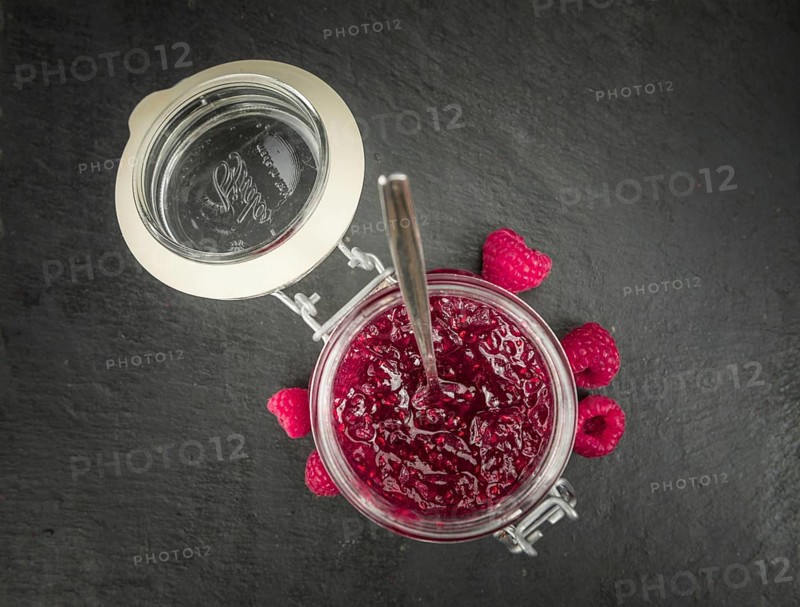 Portion of Raspberry Jam on a rustic slate slab, selective focus, close-up shot