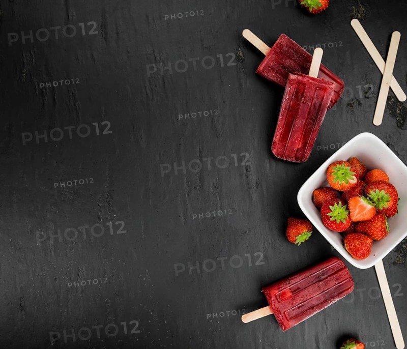Strawberry Popsicles (close-up shot, selective focus) on a rustic background