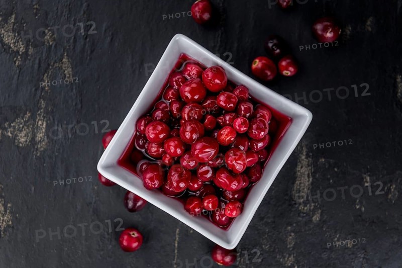 Healthy Canned Cranberries on a vintage slate slab (close-up shot, selective focus)
