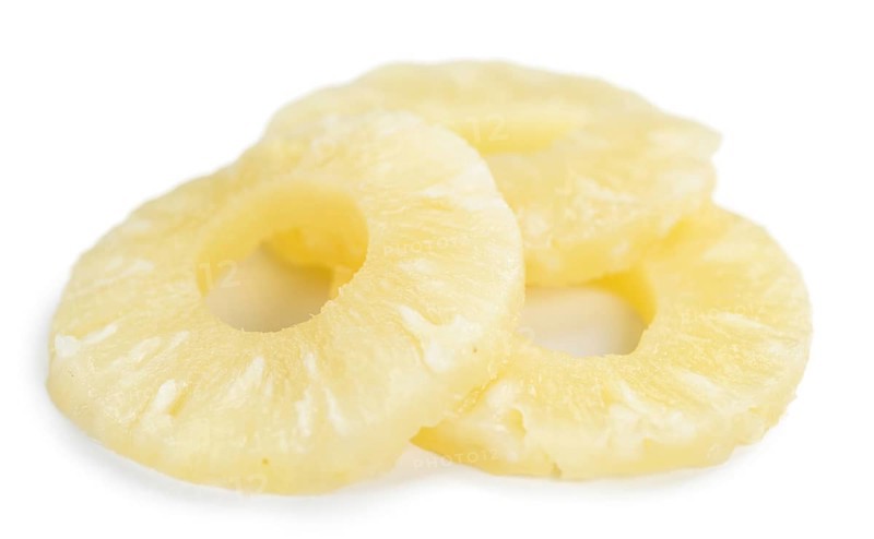 Portion of Preserved Pineapple Rings as detailed close-up shot isolated on white background