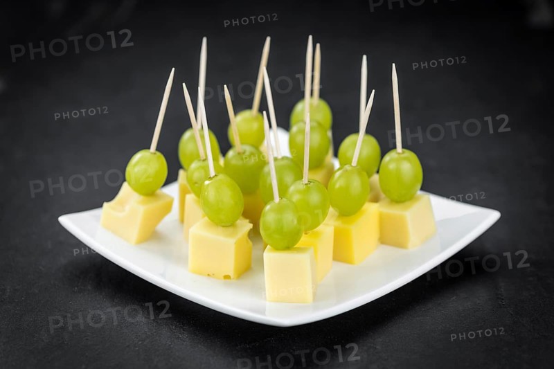 Cheese blocks with grapes as close-up shot (selective focus, partyfood)