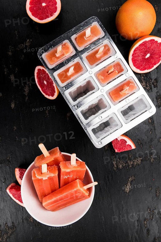 Some freshly made Grapefruit Popsicles (with some fresh fruits, selective focus)