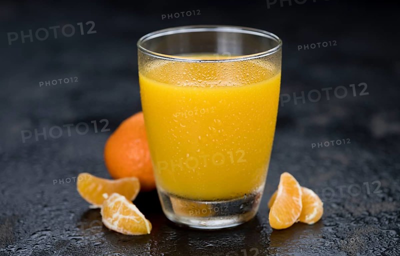 Homemade Tangerine Juice (close-up shot, selective focus) on a rustic background