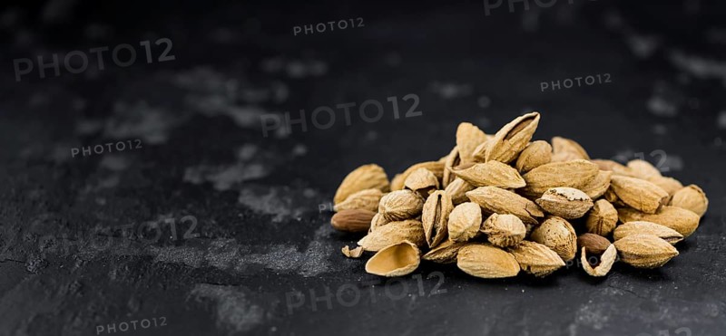 Dark slate slab with roasted and salted Almonds (in the shell)