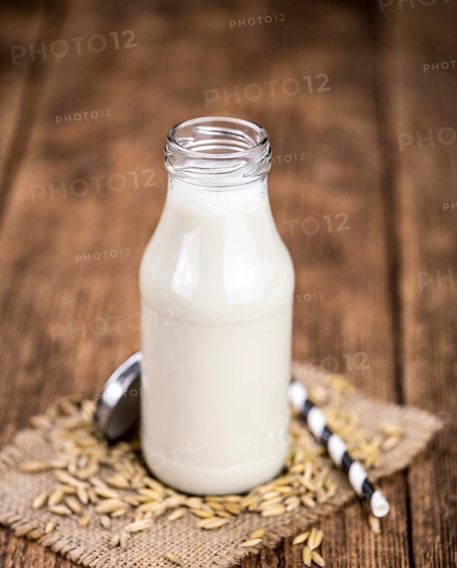 Healthy Oat Milk on a wooden table as detailed close-up shot (selective focus)