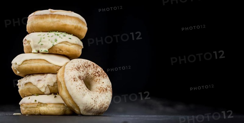 Some fresh made white chocolate Donuts (selective focus, close-up shot)