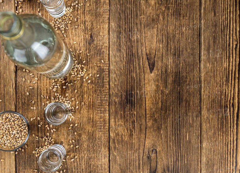 Vintage wooden table with Wheat Liqueur (selective focus, close-up shot)