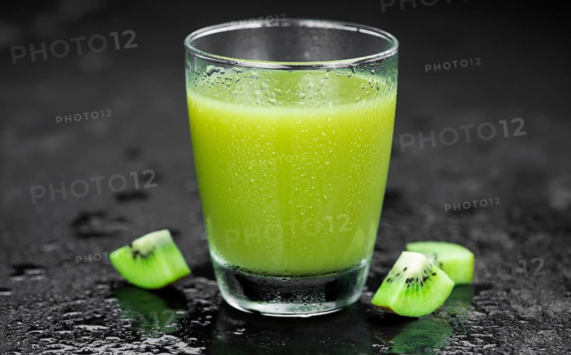 Some fresh homemade Kiwi Smoothies on a slate slab (close-up shot, selective focus)