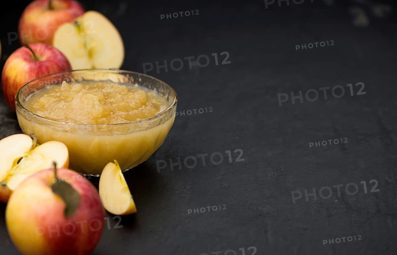 Homemade Applesauce (selective focus, close-up shot) on vintage background with some fresh fruits