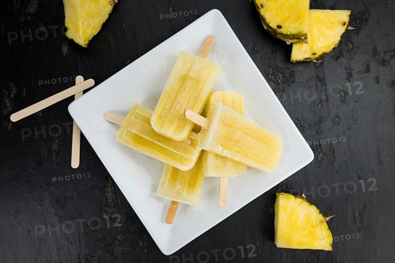 A rustic slate slab with homemade Popsicles (selective focus, close-up shot)