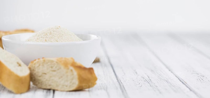 Old wooden table with fresh Breadcrumbs (close-up shot, selective focus)