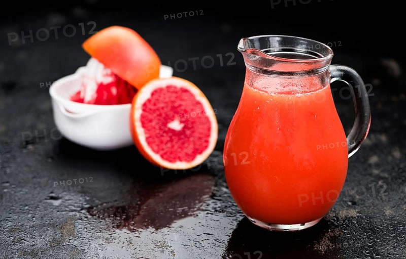 Slate slab with freshly squeezed Grapefruit Juice (selective focus, close-up shot)