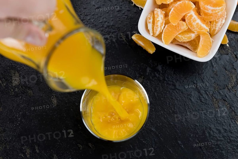 Fresh made Tangerine Juice on a vintage slate slab (selective focus)