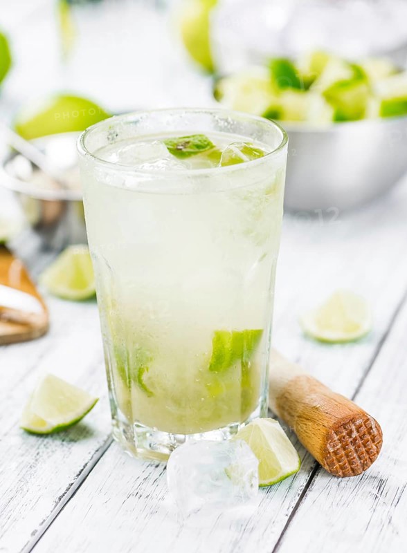 Fresh made Caipirinha with ingredients in the background