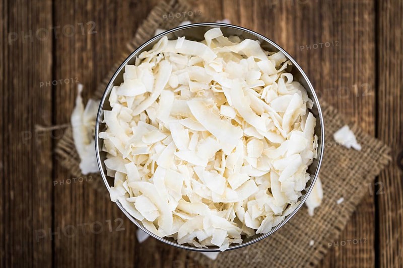 Coconut Chips (fresh) as detailed close-up shot, selective focus)