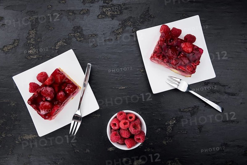Fresh made Raspberry Cake on a rustic slate slab (close-up shot, selective focus)