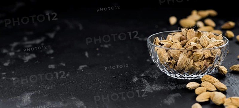 Almonds in shell (roasted and salted) on a vintage background (close-up shot)