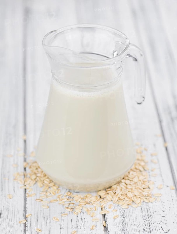 Wooden table with Oat Milk (detailed close-up shot, selective focus)