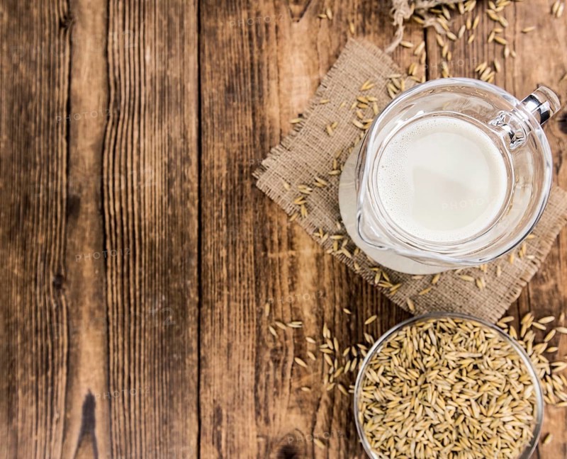 Wooden table with Oat Milk (detailed close-up shot, selective focus)