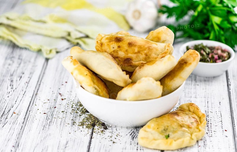 Portion of healthy Empanadas on an old wooden table (selective focus, close-up shot)