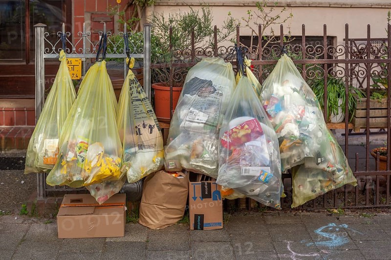 Yellow bags for plastic waste, hanging on a garden fence in front of a house entrance, waste separation, Bremen, Germany, Europe